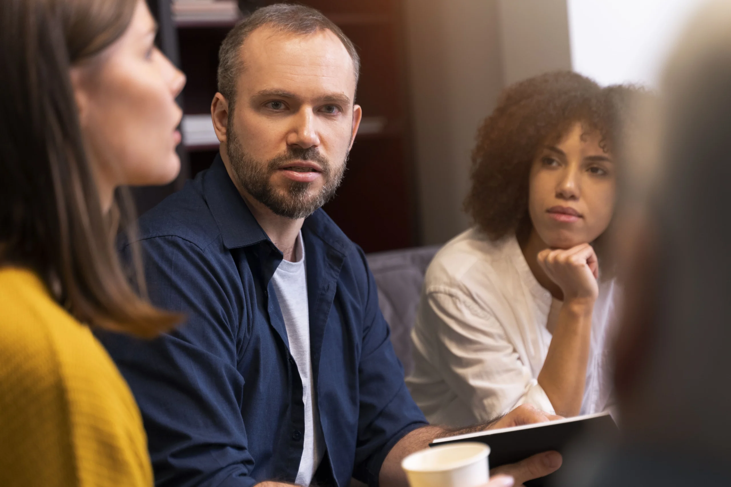 A man and woman discuss details in a meeting regarding a class action lawsuit.